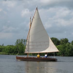 A traditional wooden half-decker, the Woodcut sails the Norfolk Broads