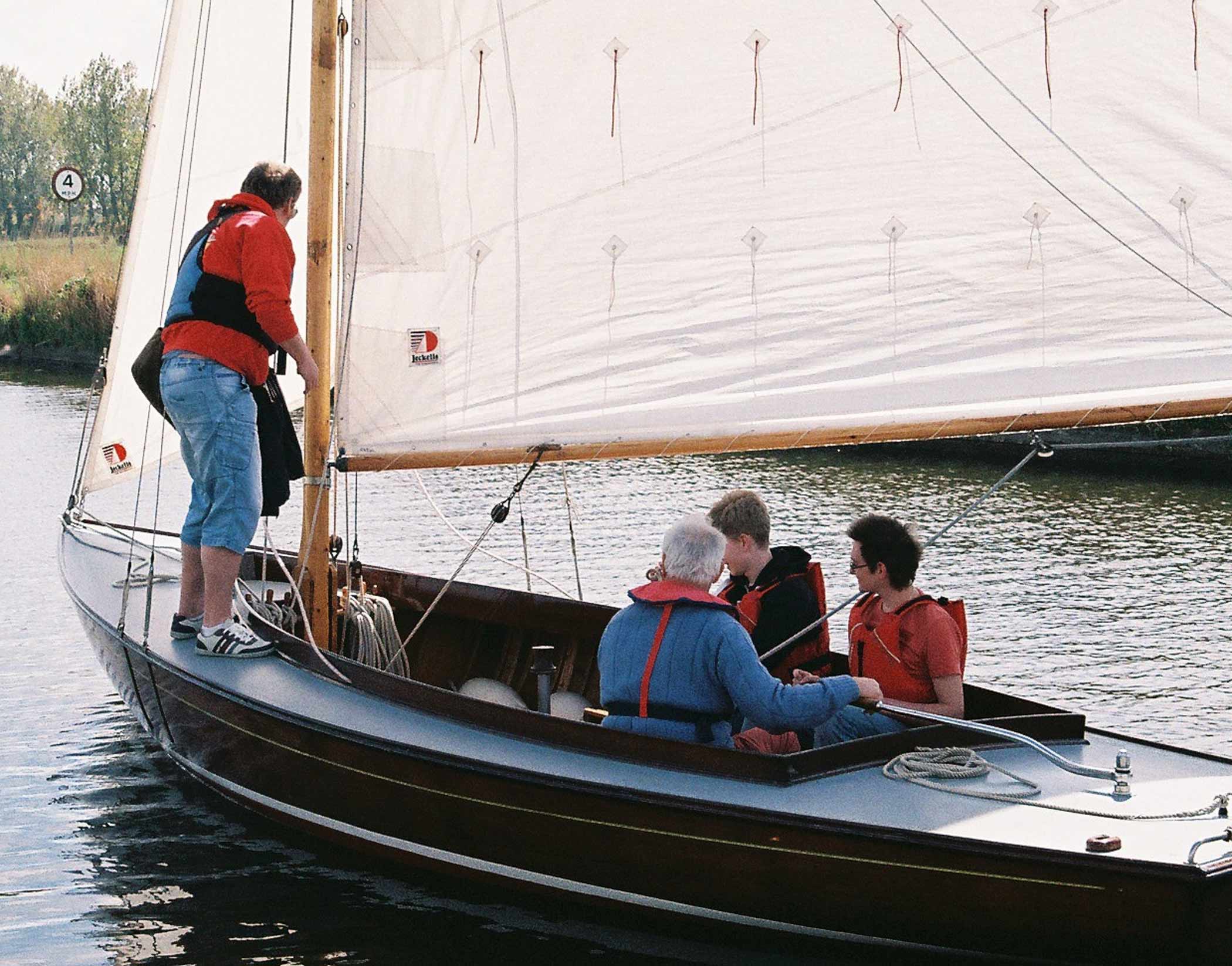 A family onboard a wooden half-decker ready to sail on the Norfolk Broads